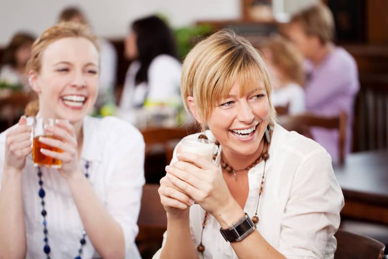 two women laughing together showing typical Swedish traits