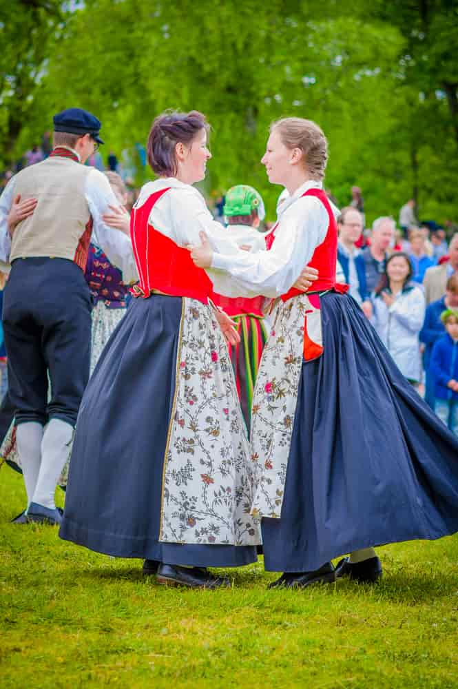 two women wearing the traditional Swedish folk costume of the region