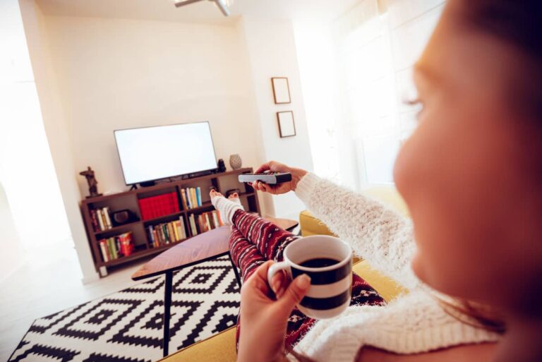 a woman with a cup of coffee while watching Scandinavian tv shows